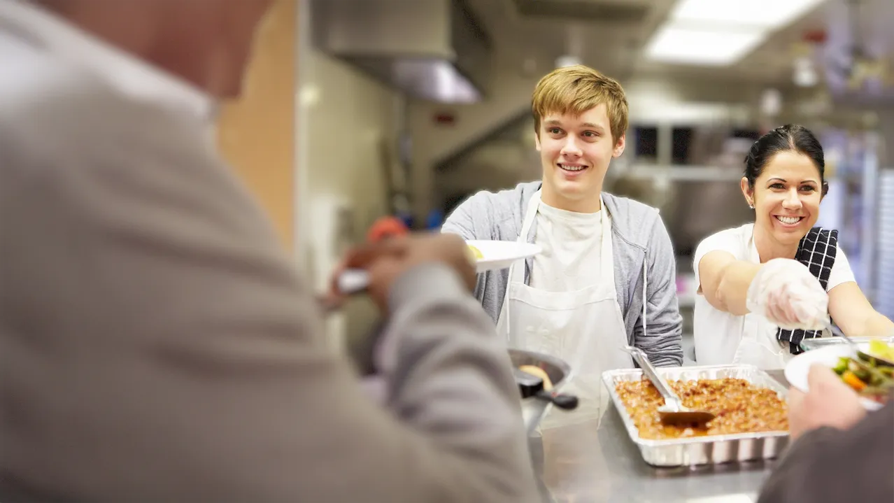 A female presenting individual walking down a city sidewalk.